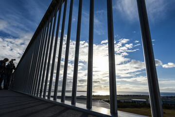 Fototapeta na wymiar Aussicht auf Himmel mit Wolken durch die Stangen eines Gitters