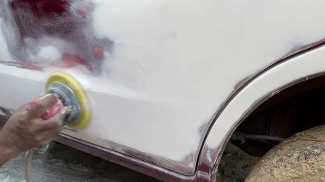 Auto body repair series : Sanding putty, The mechanic works with a grinding tool. Sanding of car elements. Garage painting car service. Repairing car section after the accident.