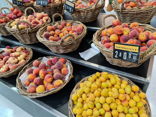 Fresh harvested apricot and peaches in basket for sale in market. Fresh delicious, sweet fruits on basket for sale in shopping mall. Fruit selling.