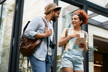 Young happy tourist couple talk to each other while entering the hotel.