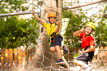 Cute children. Boy and girl climbing in a rope playground structure at adventure park