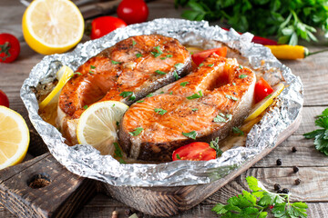 Grilled salmon fish with seasoning and various vegetables on table