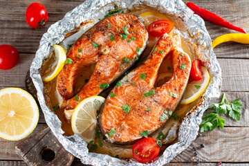 Fresh cooked delicious salmon steak with spices and herbs baked on a grill on a table. Healthy...