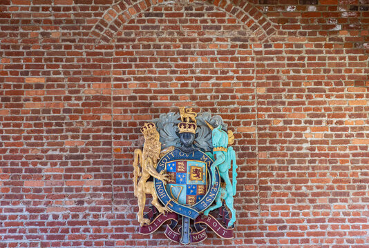 Jamestowne, VA, USA - April 1, 2013: Historic site. English Royal Coat of Arms against red brick wall. Motto is Dieu et mon Droit.