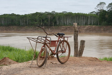 Fototapeta na wymiar Bicicleta antiga modelo cargueira parada na beira do rio