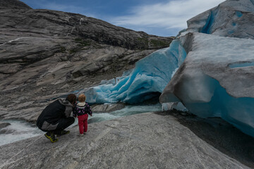 Dad and son take pictures of the glacier.Norway.