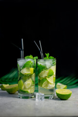 alcoholic drink mojito cocktail with lime and mint and palm leaf