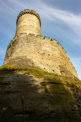 Naklejka premium A circular stone tower behind the walls with the battlements of a Gothic castle.