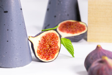 Fresh Fig with mint leaf on gray stands and podiums over white background, equilibrium food, Healthy Summer Food, Creative Concept