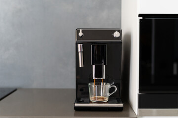 Coffee making machine pouring espresso into glass