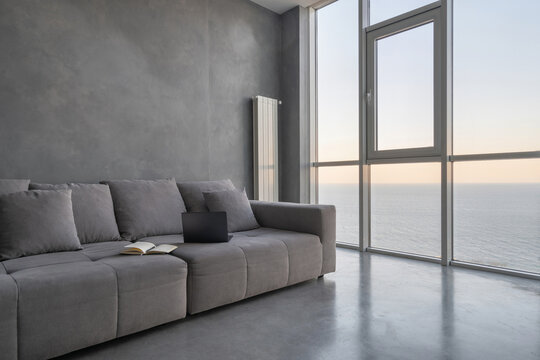 Modern laptop on grey couch in hotel room