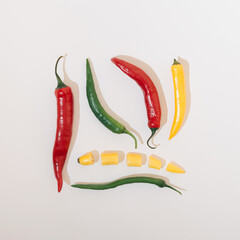 Hot peppers vegetables in several colors arranged in a square shape on a white background. Food concept