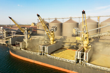 Loading grain into holds of sea cargo vessel through an automatic line in seaport from silos of grain storage. Bunkering of dry cargo ship with grain