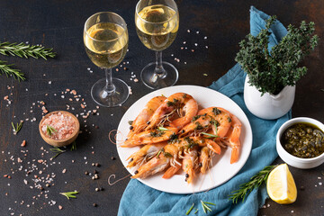 Shrimp on a plate. Wine in glasses. Seafood. Top view. Supper. Dark background