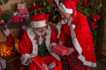 Santa Claus and wife Mrs. Claus near fireplace