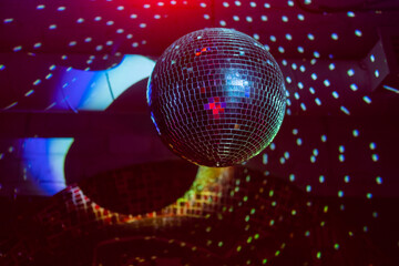 Party disco mirror ball reflecting purple lights.