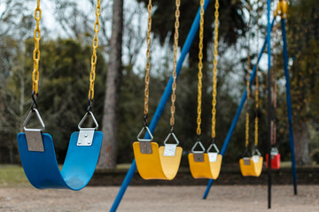 close-up, horizontal shot of colorful park swings