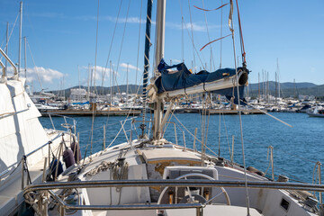 Obraz premium Moored nautical vessels at sea port San Antonio de Portmany, Balearic Islands, Ibiza, Spain. Sunny spring day.
