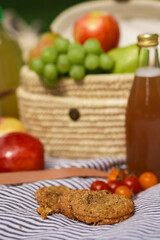 picnic on striped blanket at summer park apples pears grapes tomatoes cookies drinks 