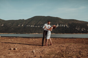 Wedding photo. A young married couple having fun and dancing by a large lake.Selective focus