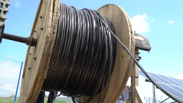Unwinding of a massive spool of cable at a construction site, laying cable