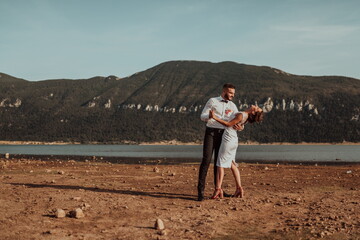 Wedding photo. A young married couple having fun and dancing by a large lake.Selective focus