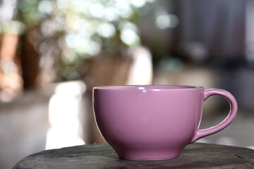 pink cup on wooden base isolated on blurred background