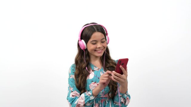 happy dancing child choose song in playlist on cell phone listening music in headphones, music.