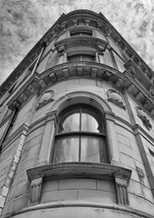 Fototapeta na wymiar monochrome perspective view of a 19th century tall stone neoclassical building with ornate curved windows in the little germany business district of bradford west yorkshire