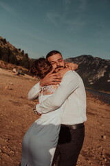Fototapeta premium Wedding photo. A young married couple having fun and dancing by a large lake.Selective focus