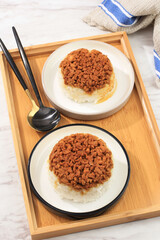 Top View Homemade Nasi Tim Ayam, Steamed Rice with Diced Chicken Soy Sauce. Indonesian Comfort Food for Breakfast. Served on Ceramic Plate with Copy Space for Text