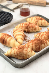 Preparation Making Croffle:  Female Chef Coating Raw Croissant Dough with Palm Sugar and Cinnamon Powder