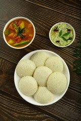 Indian vegetarian diet foods- homemade rice idly, idli iddly served with coconut chutney and sambar.