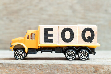 Toy truck hold alphabet letter block in word EOQ (Abbreviation of Economic order quantity) on wood background