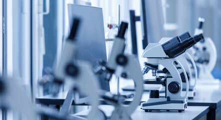 Close up shot of two eyes viewfinder scientific microscope in row of one eye microscopes line in blurred foreground on laboratory working table using for monitoring coronavirus covid 19 virus samples