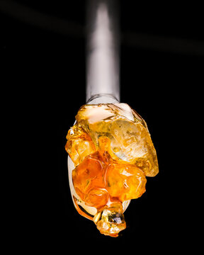 Gold And Amber Colored Cannabis Diamonds On A Glass Dab Tool