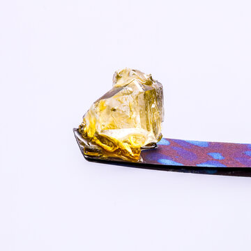 Live Resin Cannabis Diamonds on Titanium Dab Tool with a White Background