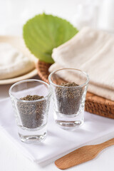 Organic perilla seeds in a glass on white background. Natural beauty spa treatment product concept.