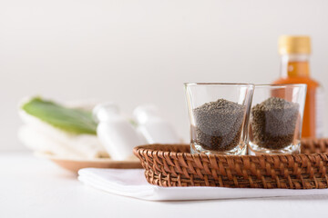 Organic perilla seeds in a glass on white background. Natural beauty spa treatment product concept.