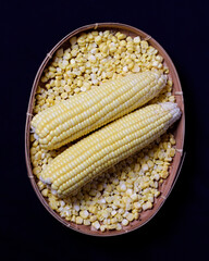 Sweet corn isolated on dark background. This corn can be served in various processed forms. Whether it's boiled, baked, or mixed with other foods to serve as a side dish or snack. Corn mockup.