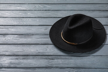 Stylish hat on dark wooden background