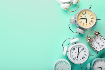 Stylish alarm clocks on color background