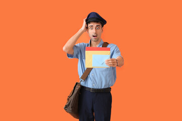 Surprised young postman with letters on color background