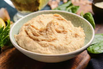 Bowl with tasty hummus on table, closeup