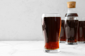 Glasses of fresh kvass on light background