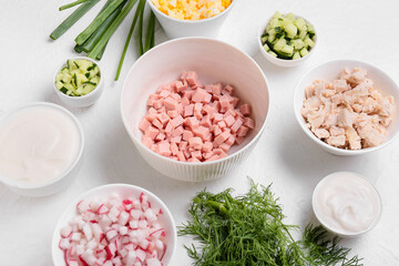 Bowls with ingredients for okroshka on light background