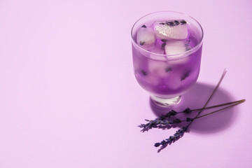 Glass of fresh cocktail with lavender on color background