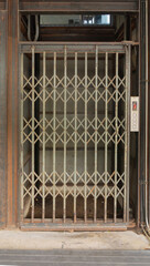 A classic old elevator lift with collapsible gate in hotel. Interior architectural element. Antique...