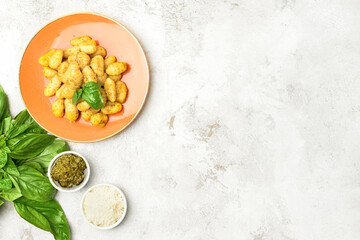 Composition with tasty pesto gnocchi on light background