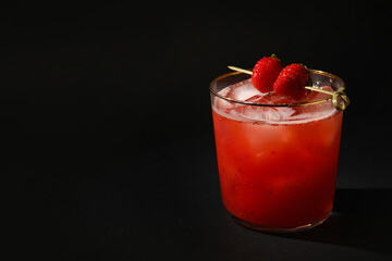 Glass of tasty strawberry margarita on dark background